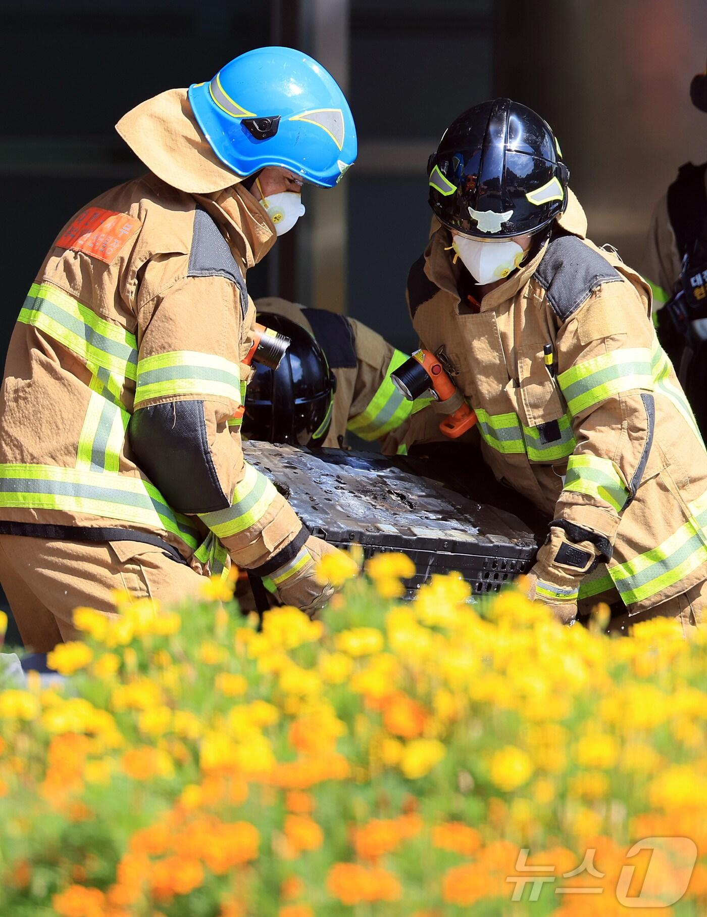 본문 이미지 - 27일 오전 대전 유성구 국가정보자원관리원 화재현장에서 소방당국 관계자들이 폭발한 리튬배터리를 옮기고 있다. 전산 자원을 통합 관리하는 행정안전부 산하 국가정보자원관리원에서 지난 26일 오후 배터리 교체 작업 중 화재가 발생, 정부 온라인 서비스 70개가 마비됐다. 2025.9.27/뉴스1 ⓒ News1 김진환 기자