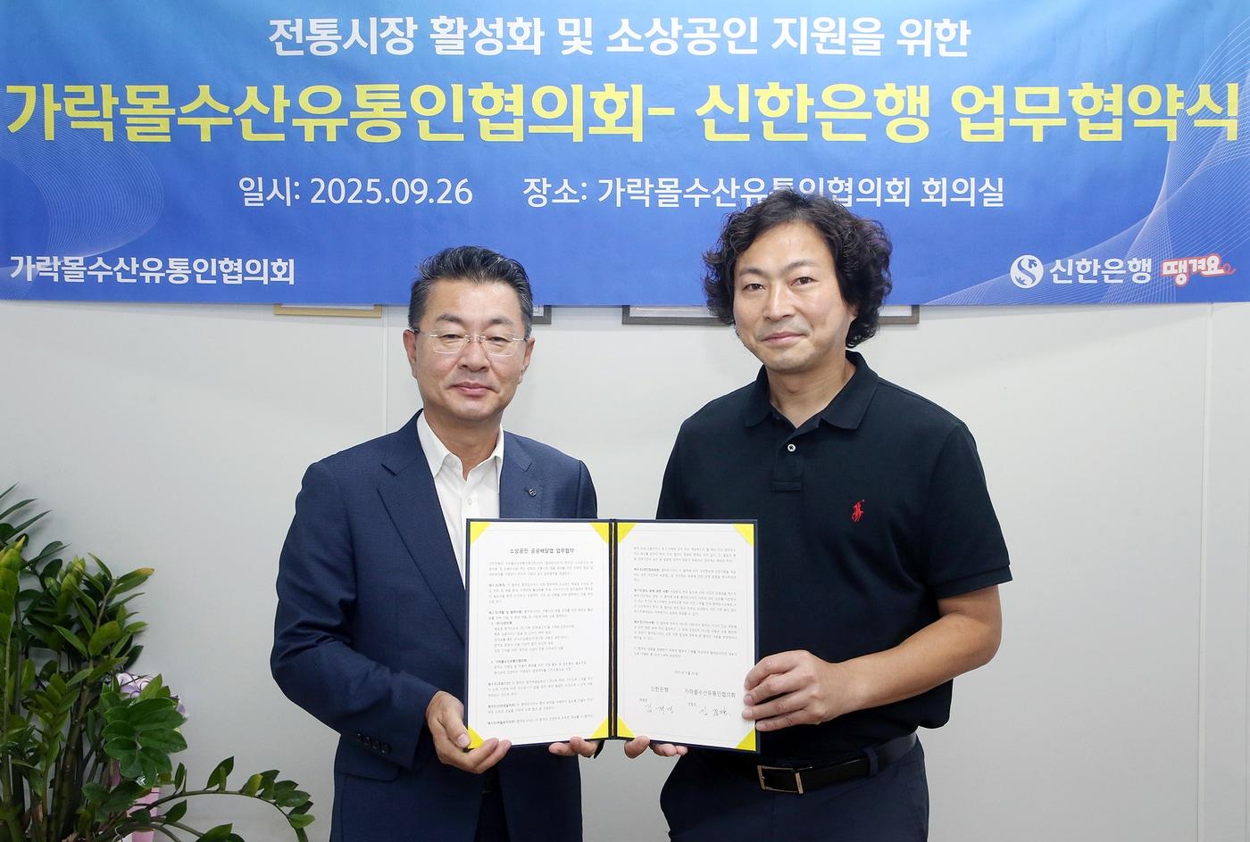 26일 서울시 송파구 소재 가락몰에서 진행된 ‘전통시장 활성화 및 소상공인 지원을 위한 가락몰수산유통인협의회–신한은행 업무협약식’에서 김재민 신한은행 영업추진1그룹장&#40;왼쪽&#41;과 김종완 가락몰수산유통인협의회 조합장이 기념촬영하는 모습&#40;신한은행 제공&#41;