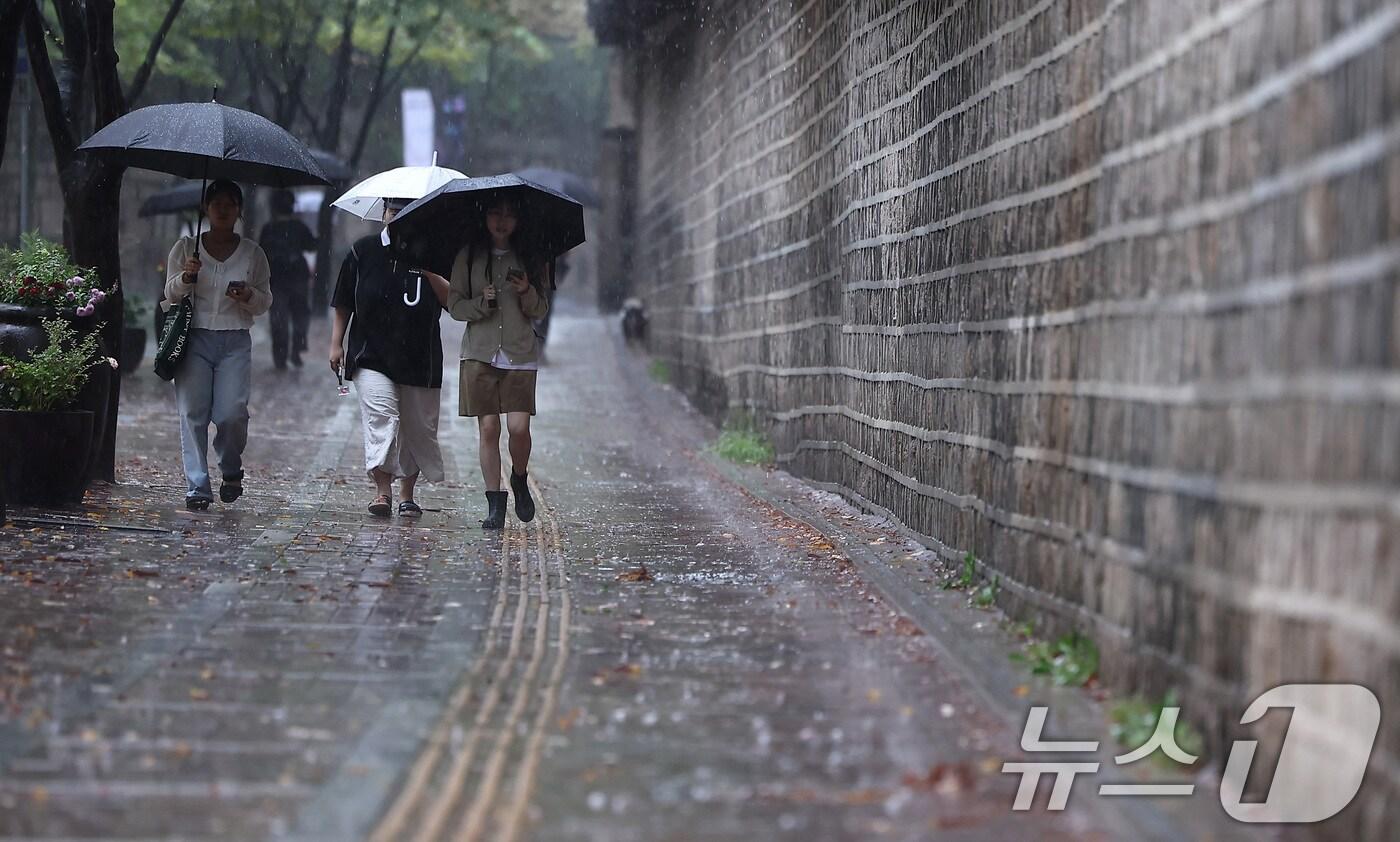 서울 중구 덕수궁 돌담길에서 시민들이 우산을 쓴 채 발걸음을 옮기고 있다. 2025.9.28/뉴스1 ⓒ News1 김성진 기자