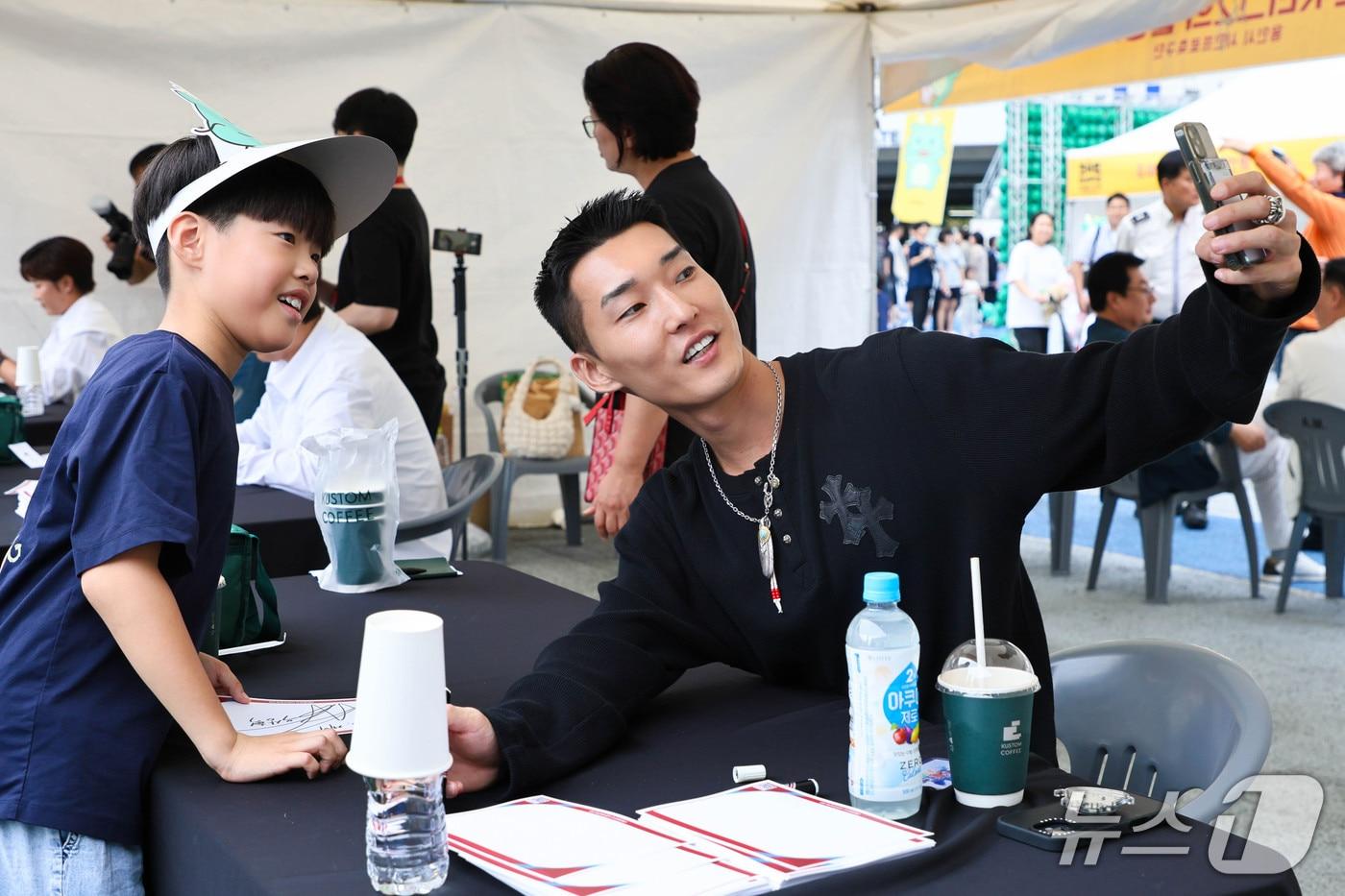 우상혁 선수가 사인회에서 어린이 팬과 셀카를 찍고 있는 모습.&#40;용인시 제공&#41;