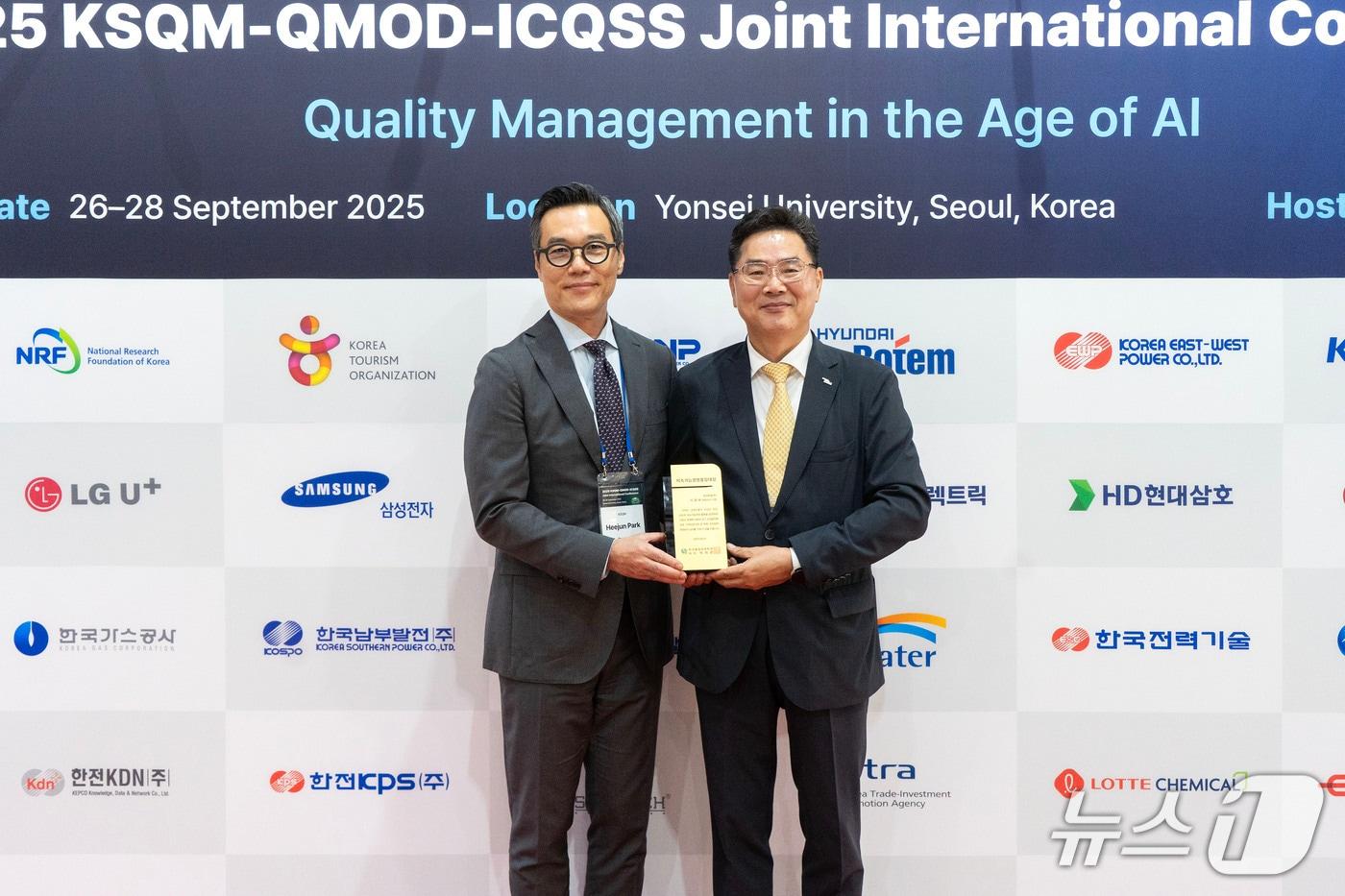 조규출 현대로템 품질본부장 상무(오른쪽)가 '2025 지속가능경영품질대상'을 수상한 후 박희준 한국품질경영학회장과 기념촬영을 하는 모습(현대로템 제공)