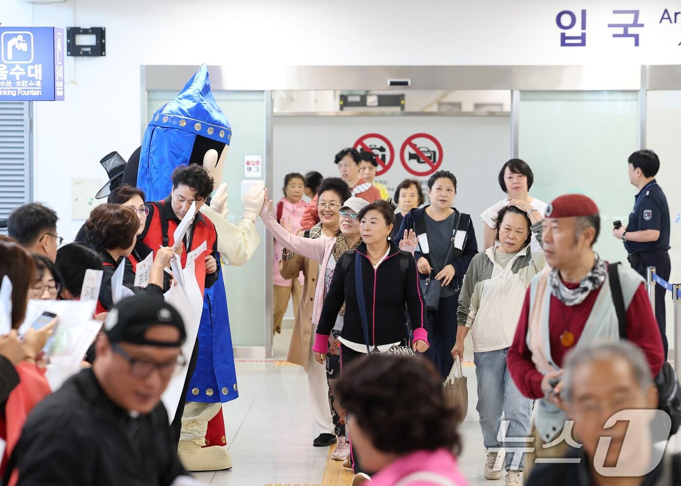 본문 이미지 - 중국 단체관광객의 무비자 입국이 시작된 29일 오전 크루즈를 타고 방한한 중국인 관광객들이 인천 연수구 인천항크루즈터미널을 통해 입국하며 손을 흔들고 있다.  2025.9.29/뉴스1 ⓒ News1 오대일 기자