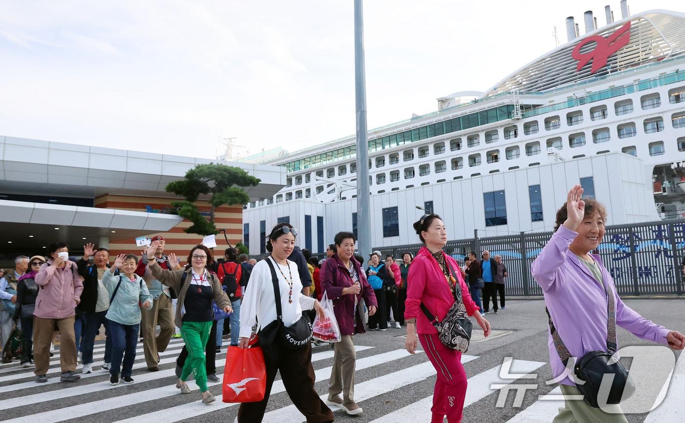 중국 단체관광객의 무비자 입국이 시작된 29일 오전 크루즈를 타고 방한한 중국인 관광객들이 인천 연수구 인천항크루즈터미널을 통해 입국하며 손을 흔들고 있다.2025.9.29/뉴스1 ⓒ News1 오대일 기자