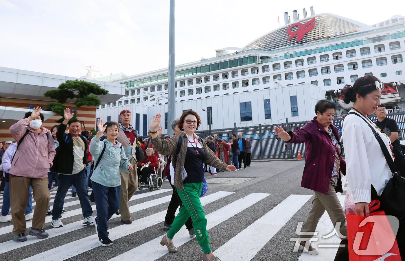 중국 단체관광객의 무비자 입국이 시작된 29일 오전 크루즈를 타고 방한한 중국인 관광객들이 인천 연수구 인천항크루즈터미널을 통해 입국하며 손을 흔들고 있다. 정부는 9월 29일부터 내년 6월 30일까지 중국인 단체관광객의 무비자 입국을 허용하기로 했다. 이 기간 중국인 단체관광객들은 15일 범위 내에서 무비자로 입국해 관광할 수 있다. 2025.9.29/뉴스1 ⓒ News1 오대일 기자