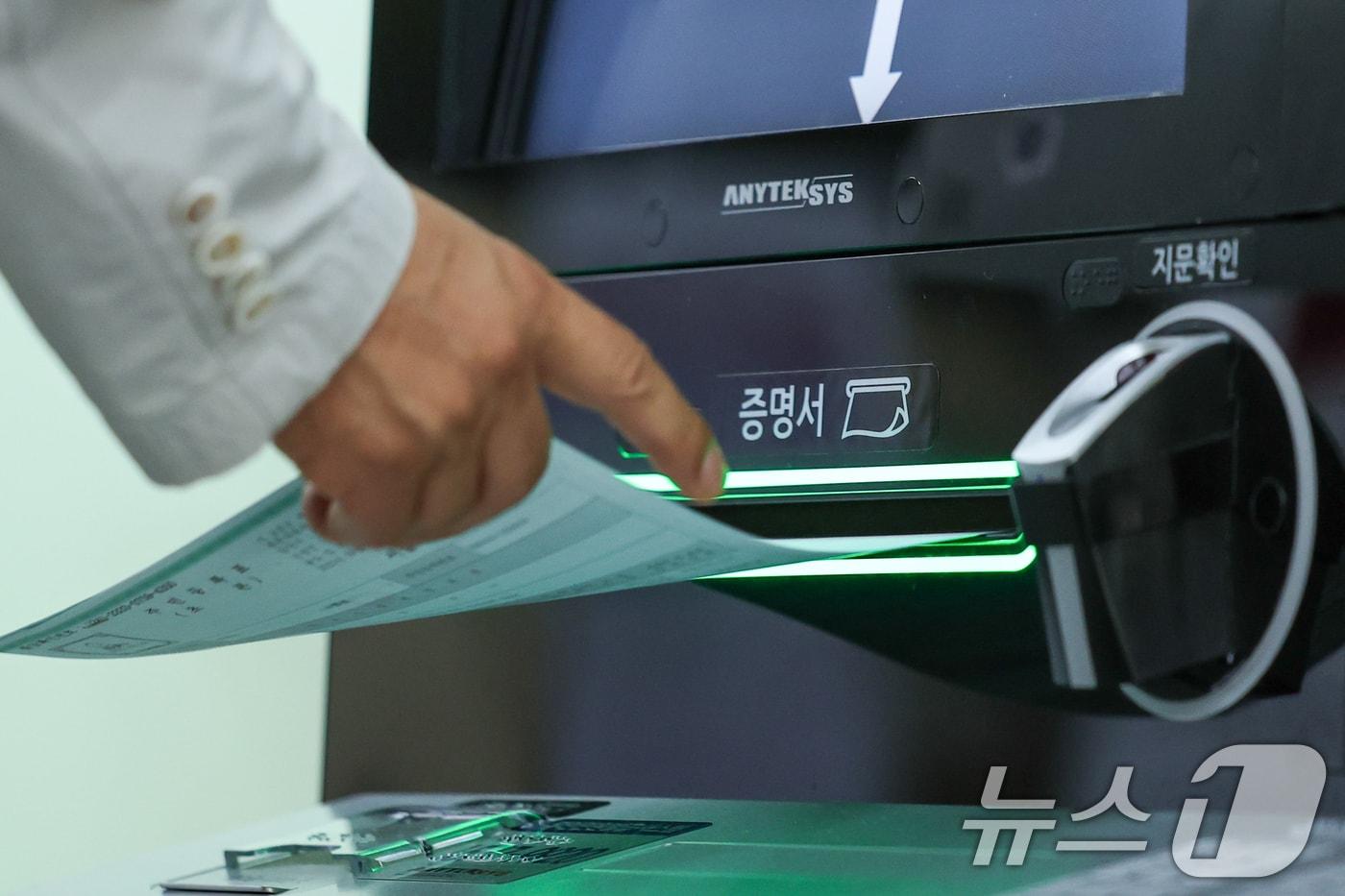 서울 종로구청에서 이용이 중단됐던 무인민원발급기가 복구돼 시민이 주민등록등본을 발급하고 있다. 2025.9.29/뉴스1 ⓒ News1 안은나 기자