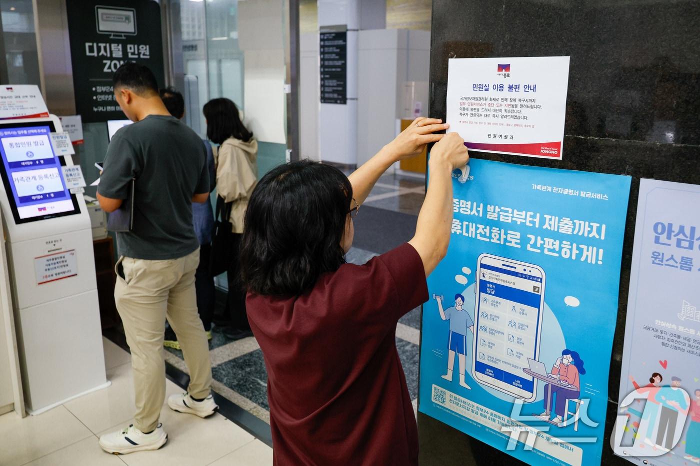 정부가 대전 국가정보자원관리원&#40;국정자원&#41; 전산실에서 발생한 화재로 중단된 행정정보시스템 복구에 총력을 기울이고 있는 29일 오전 서울 종로구청에서 직원이 민원실 이용 불편 안내문을 부착하고 있다. 2025.9.29/뉴스1 ⓒ News1 안은나 기자