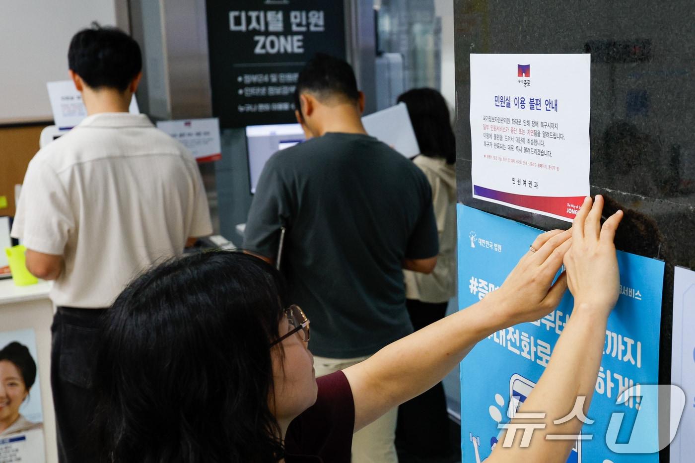 정부가 대전 국가정보자원관리원&#40;국정자원&#41; 전산실에서 발생한 화재로 중단된 행정정보시스템 복구에 총력을 기울이고 있는 29일 오전 서울 종로구청에서 직원이 민원실 이용 불편 안내문을 부착하고 있다. 2025.9.29/뉴스1 ⓒ News1 안은나 기자