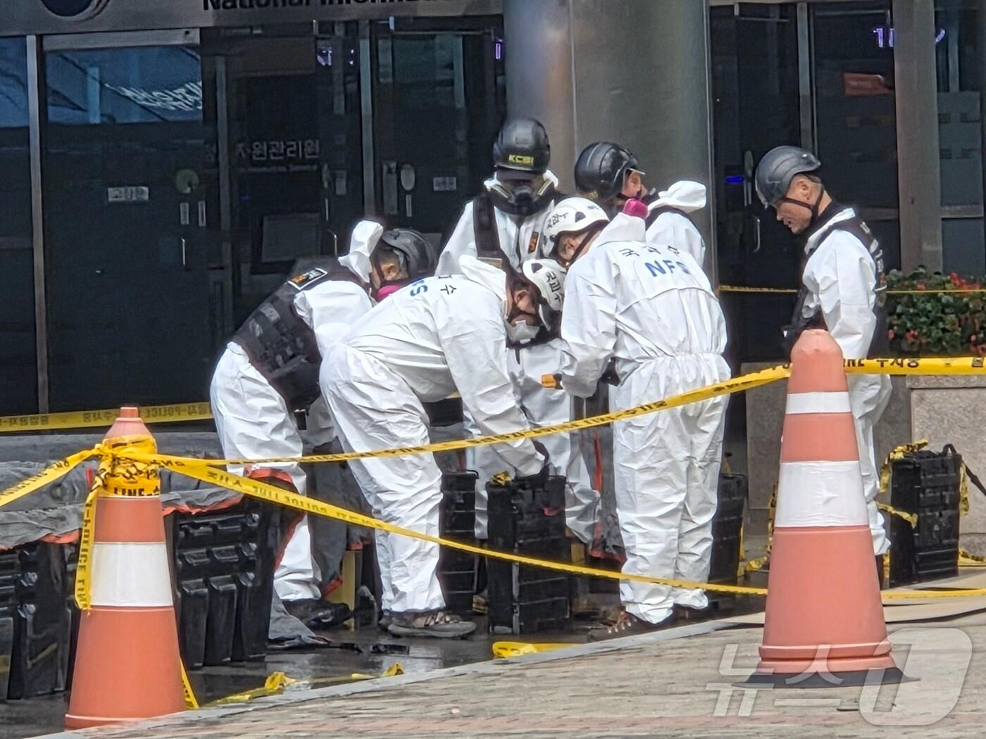 본문 이미지 - 29일 오전 대전 국가정보자원관리원 화재 3일차 합동감식이 시작된 가운데, 감식반이 화재 현장에서 반출한 리튬이온 배터리를 간이수조에서 건져 살피고 있다. 2025.9.29/뉴스1 ⓒ News1 김종서 기자