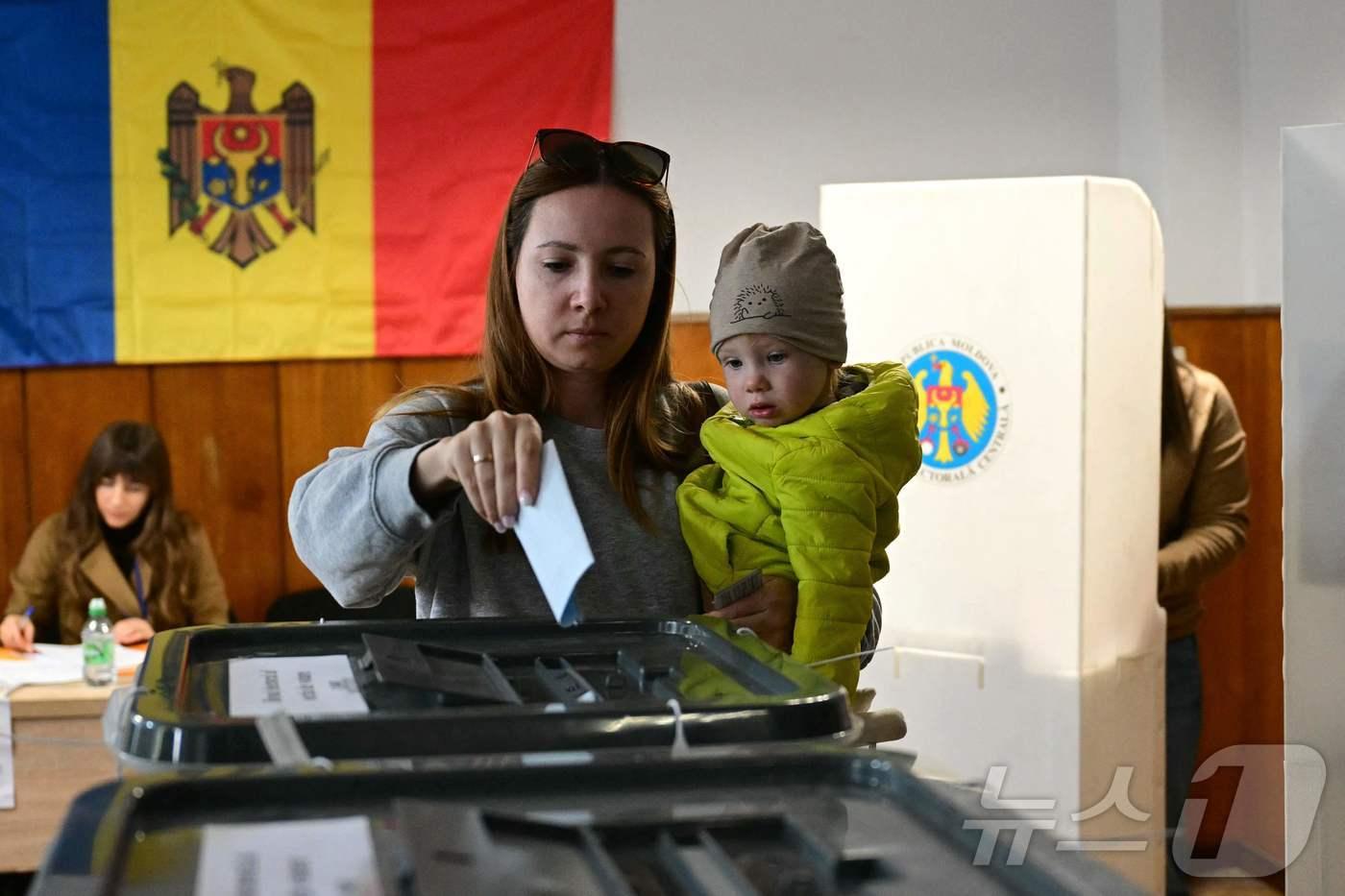 몰도바 총선이 실시된 지난 28일&#40;현지시각&#41; 수도 키시나우의 한 투표소에서 한 여성이 아이를 품에 안고 투표하고 있다. ⓒ AFP=뉴스1