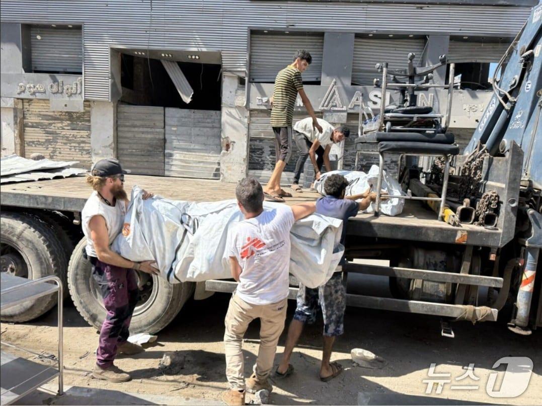 본문 이미지 - 국경없는의사회 물류팀 직원들이 가자시티 소재 진료소 앞에서 텐트와 물품을 트럭에 실으며 현장 철수를 준비하고 있다. (국경없는의사회 제공)