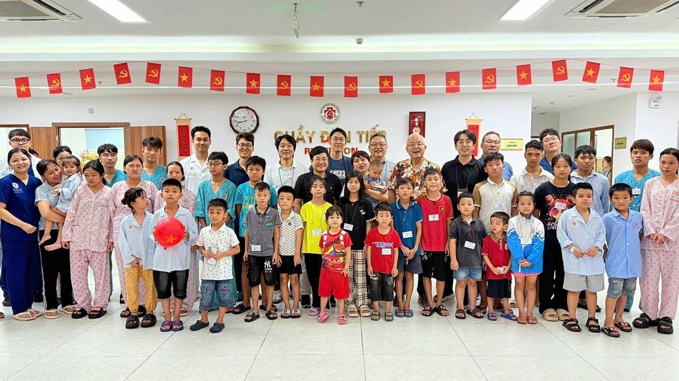 봉사단이 얼굴기형 수술을 받은 아이들과 함께 기념사진을 촬영하고 있다.(분당서울대병원 제공)