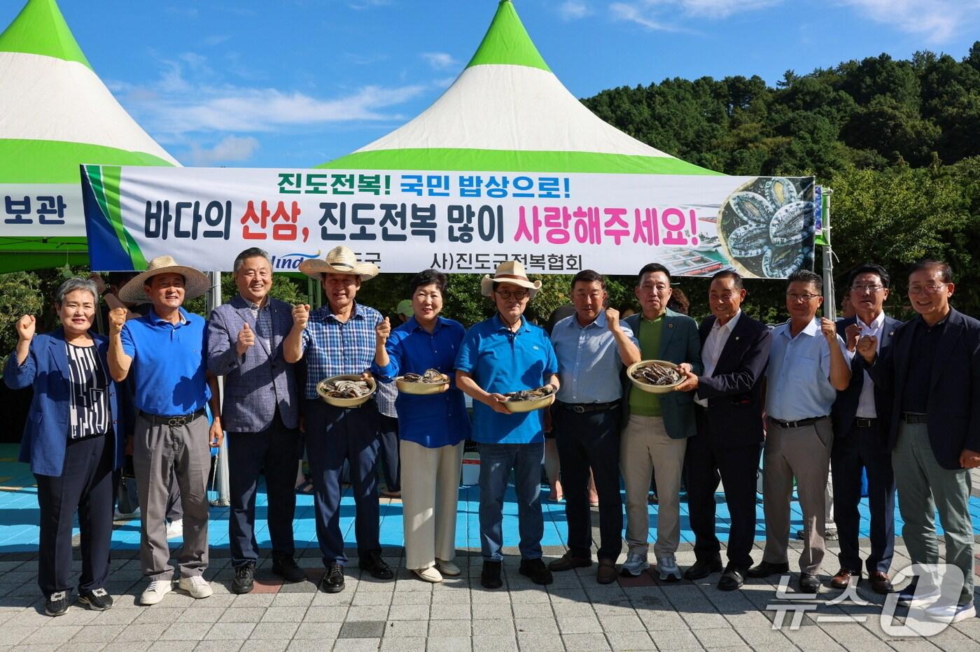 박지원 국회의원&#40;왼쪽에서 여섯번 째&#41;과 김희수 군수&#40;왼쪽 네번 째&#41; 등 관계자들이 &#39;진도 전복 현장 할인 판매&#39;행사에서 기념사진을 찍고 있다.&#40;진도군 제공, 재판매 및 DB 금지&#41;/뉴스1