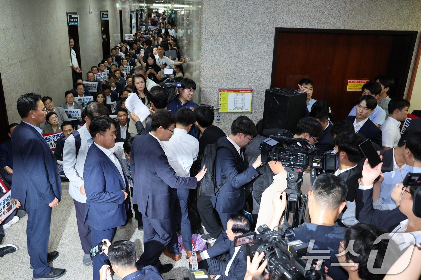 국민의힘 의원들이 지난달 3일 오후 서울 여의도 국회 국민의힘 원내대표실 앞에서 긴급 의원총회를 가진 가운데 내란특검 수사관들이 원내대표실 압수수색에 실패한 후 국회를 나서고 있다./뉴스1 ⓒ News1 신웅수 기자