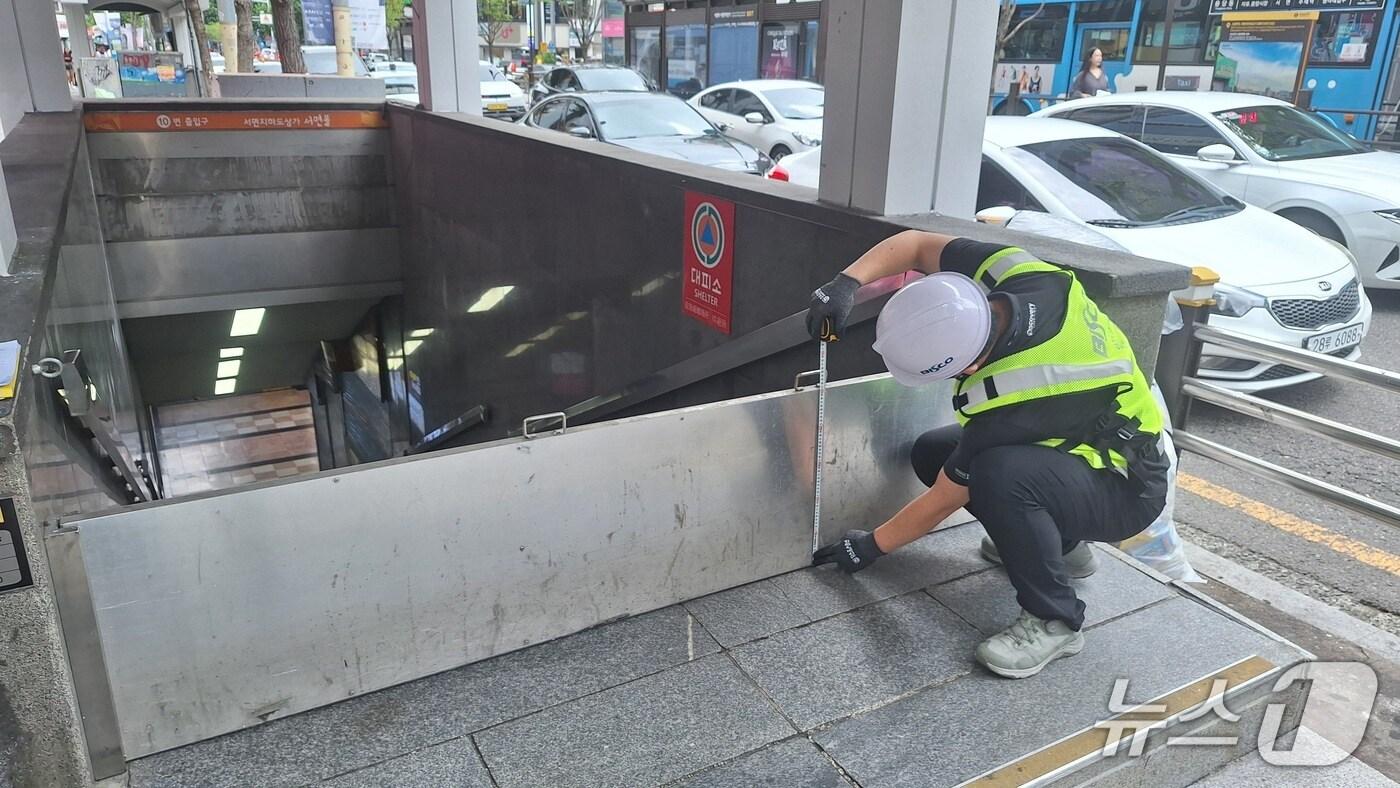 부산시설공단 관계자가 태풍으로 인한 침수사태를 막기 위해 서면지하도상가 부전몰 5번 출구 차수판 상태를 확인하고 있다.