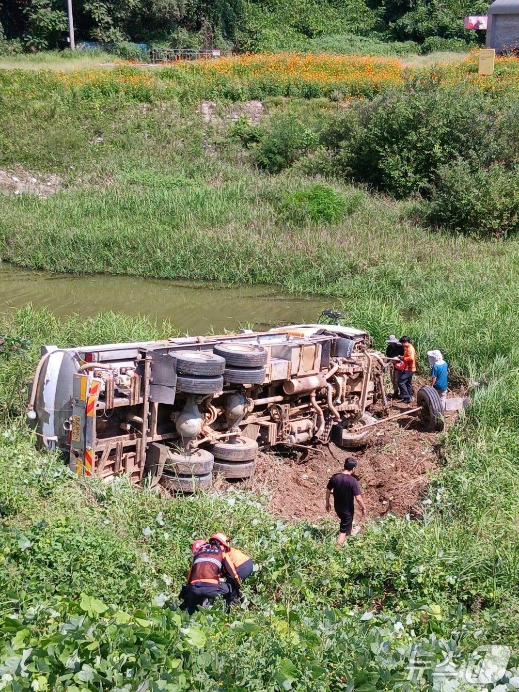본문 이미지 - 3일 오전 11시 34분쯤 충북 청주시 청원구 오창읍의 한 도로에서 15톤 살수차가 8m 아래 하천변으로 추락해 2명이 다쳤다.(청주동부소방서 제공. 재판매 및 DB금지)/뉴스1