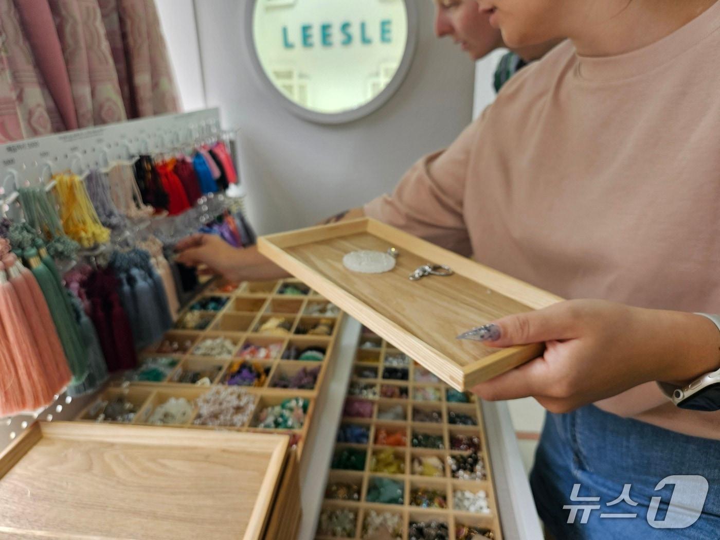 본문 이미지 - 1일 서울 종로구 인사동의 모던 한복 브랜드 '리슬'을 방문한 러시아인 관광객이 노리개 만들기 체험을 위해 부자재를 고르고 있다. 2025.09.01/뉴스1 ⓒ News1 유채연 기자