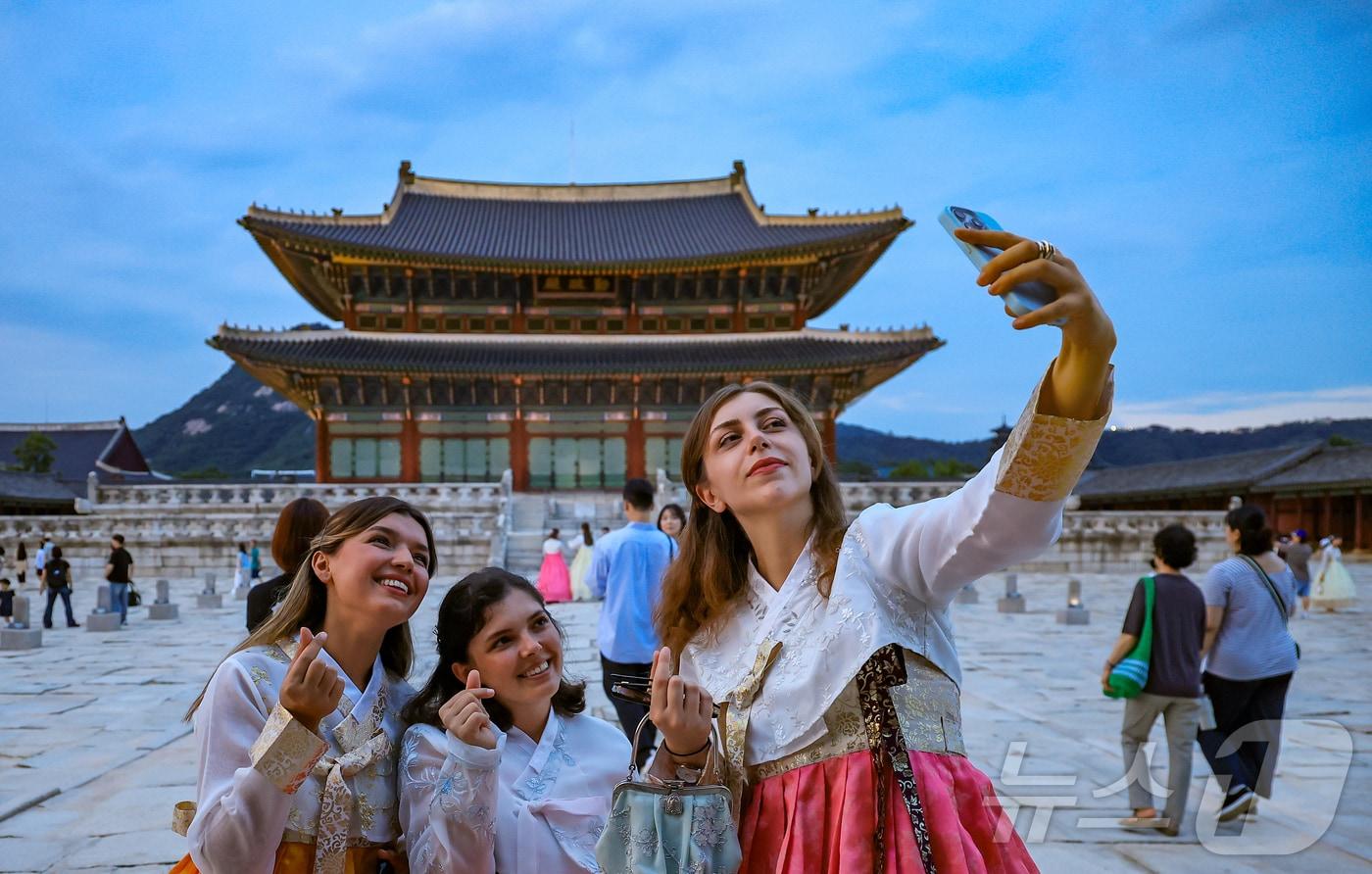 경복궁 야간 관람이 시작된 3일 오후 서울 종로구 경복궁을 찾은 외국인 관광객들이 근정전을 배경으로 셀카를 찍고 있다.  2025.9.3/뉴스1 ⓒ News1 김진환 기자