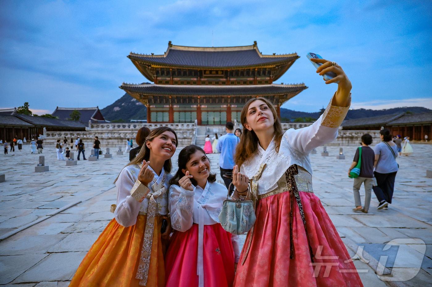경복궁 야간 관람이 시작된 3일 오후 서울 종로구 경복궁을 찾은 외국인 관광객들이 근정전을 배경으로 셀카를 찍고 있다. . 2025.9.3/뉴스1 ⓒ News1 김진환 기자