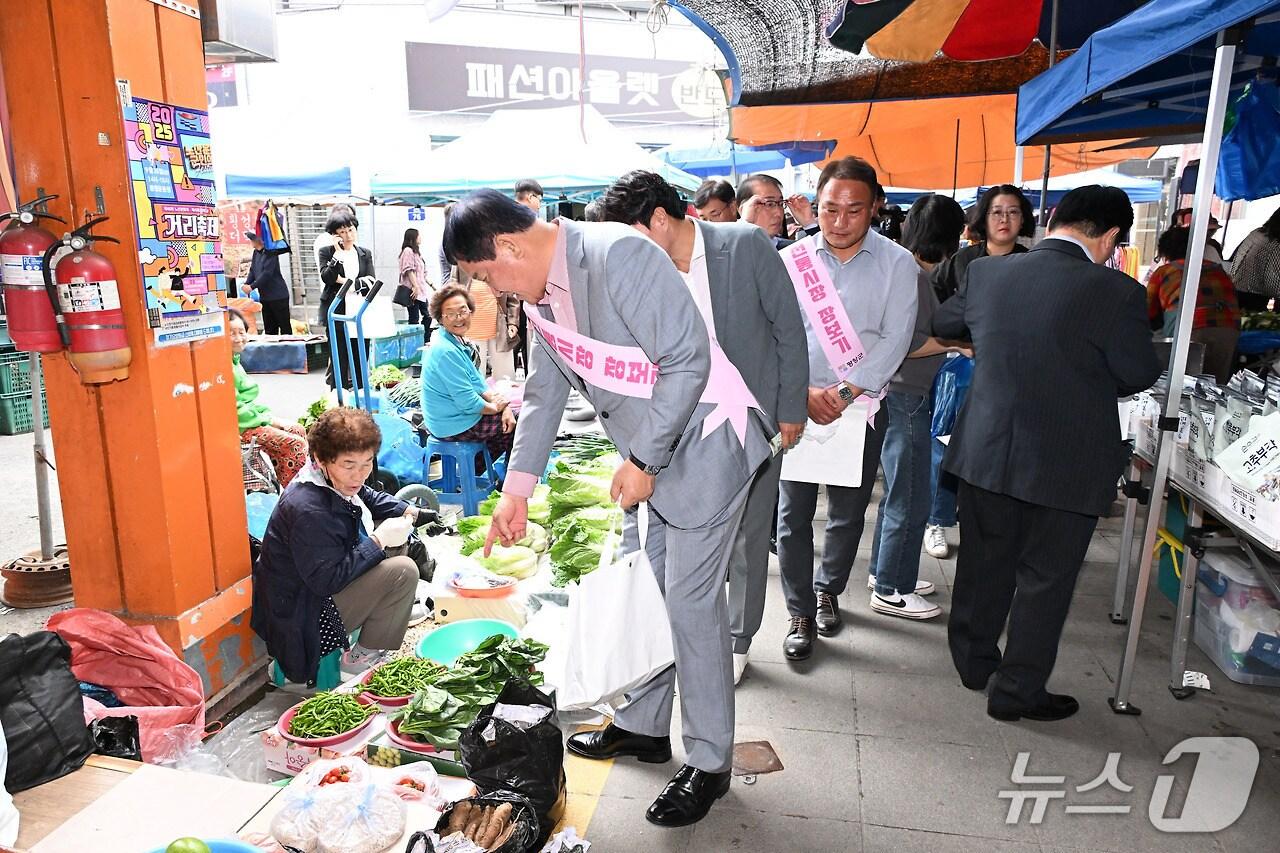 본문 이미지 - 심재국 강원 평창군수가 30일 평창전통시장에서 강원도청 및 평창군청 직원 등 100여 명과 함께 전통시장 장보기 행사에 나섰다. &#40;평창군 제공. 재판매 및 DB금지&#41; 2025.9.30/뉴스1