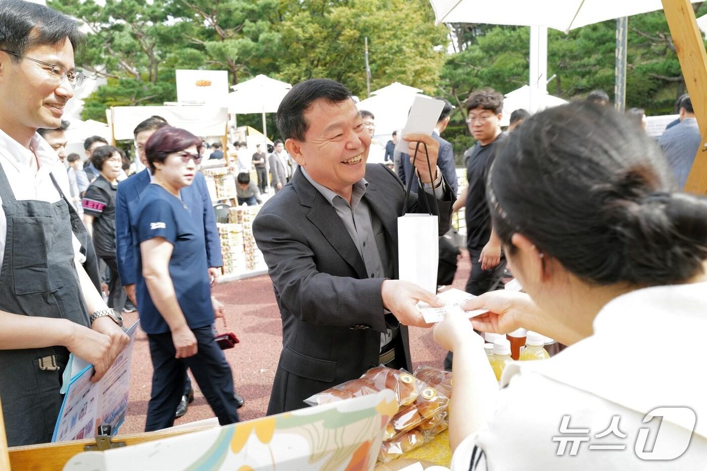 윤석대 한국수자원공사 사장(가운데)이 ‘이음장날’에서 지역 농가의 판매부스를 방문하고 있다. (한국수자원공사 제공.재판매 및 DB금지)/뉴스1