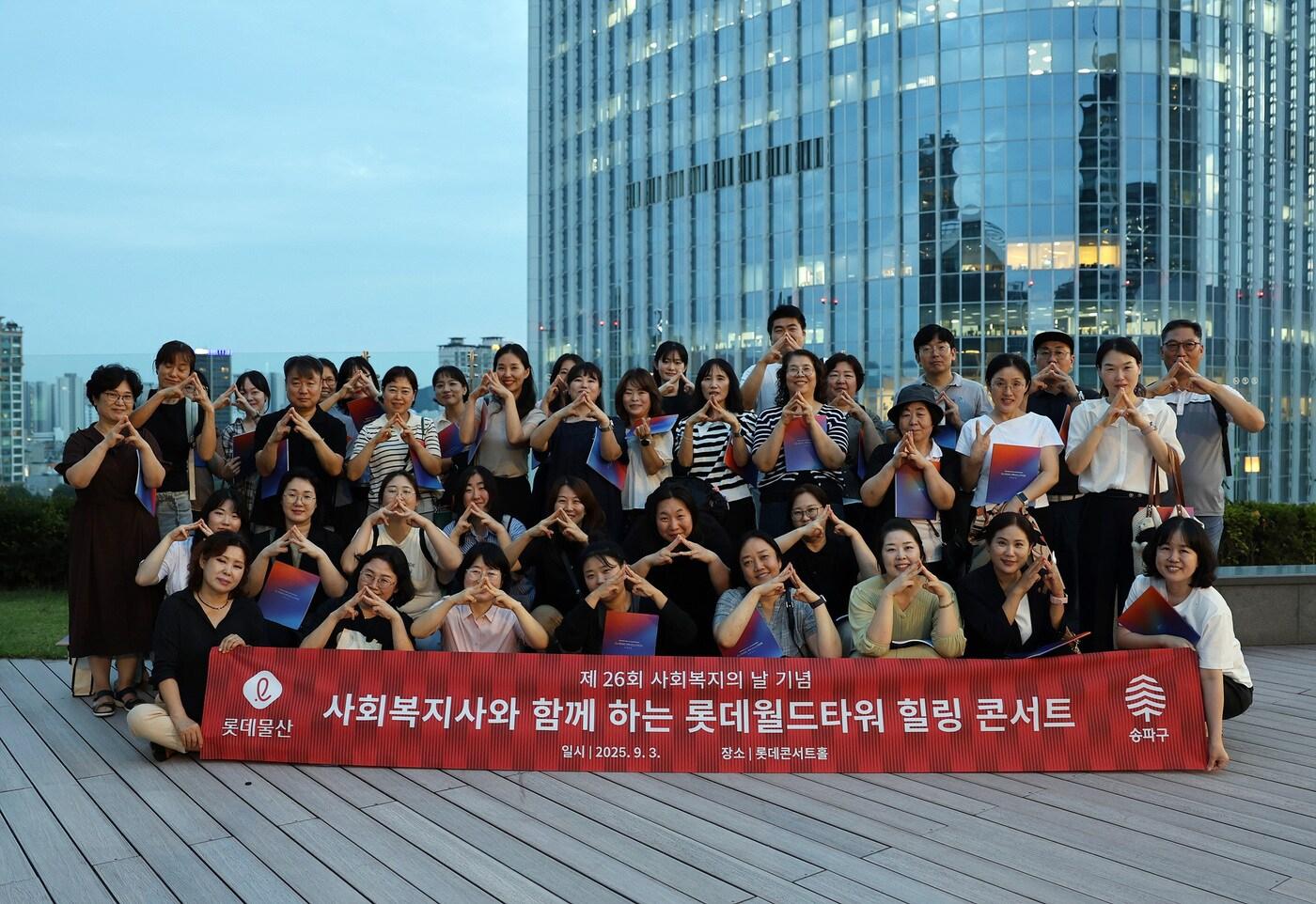 사회복지사와 함께 하는 롯데월드타워 힐링 콘서트' 참가자들이 '롯데월드타워 123층'을 수어로 표현하며 기념사진을 찍고 있다. (롯데물산 제공).