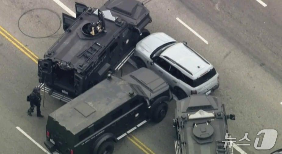 본문 이미지 - 2일(현지시간) 한 여성이 미국 로스앤젤레스의 한 대로에서 차량에 탑승한 채 경찰과 대치전을 벌이고 있다. <출처=KTLA-TV 기사 갈무리>