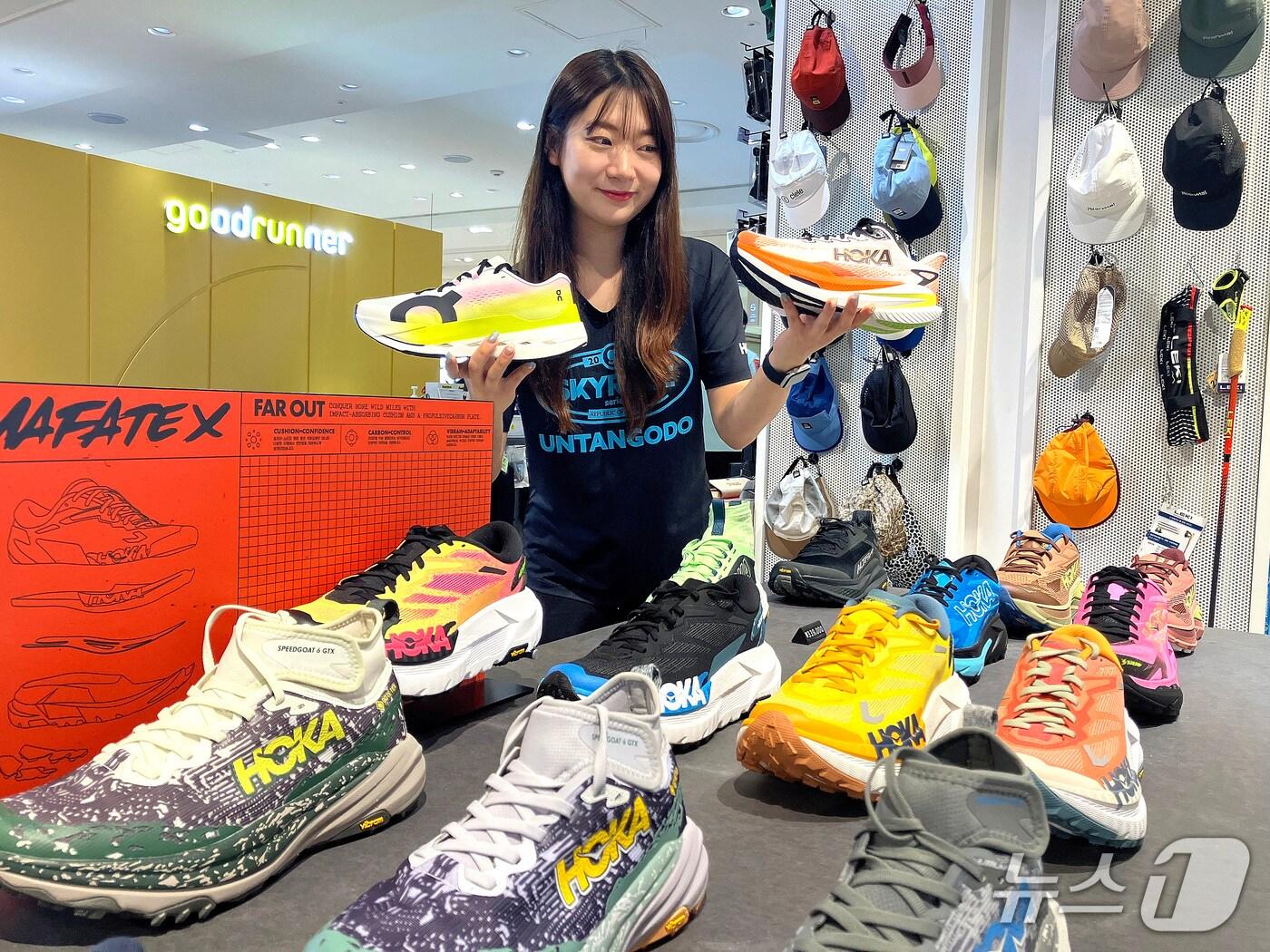 본문 이미지 - 롯데백화점 부산본점 관계자가 런 인 부산 행사를 맞아 러닝화를 소개하고 있다.&#40;롯데백화점 부산본점 제공. 재판매 및 DB 금지&#41;