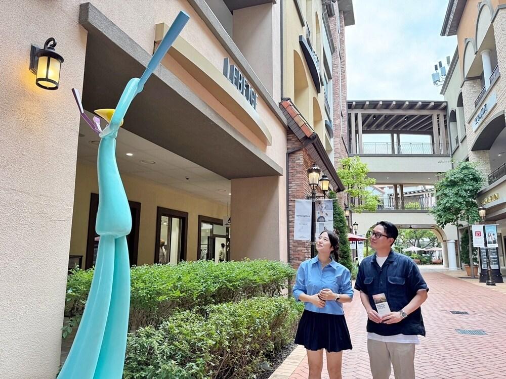 본문 이미지 - 시흥 프리미엄 아울렛에 전시된 조각을 감상하는 고객(신세계사이먼 제공)