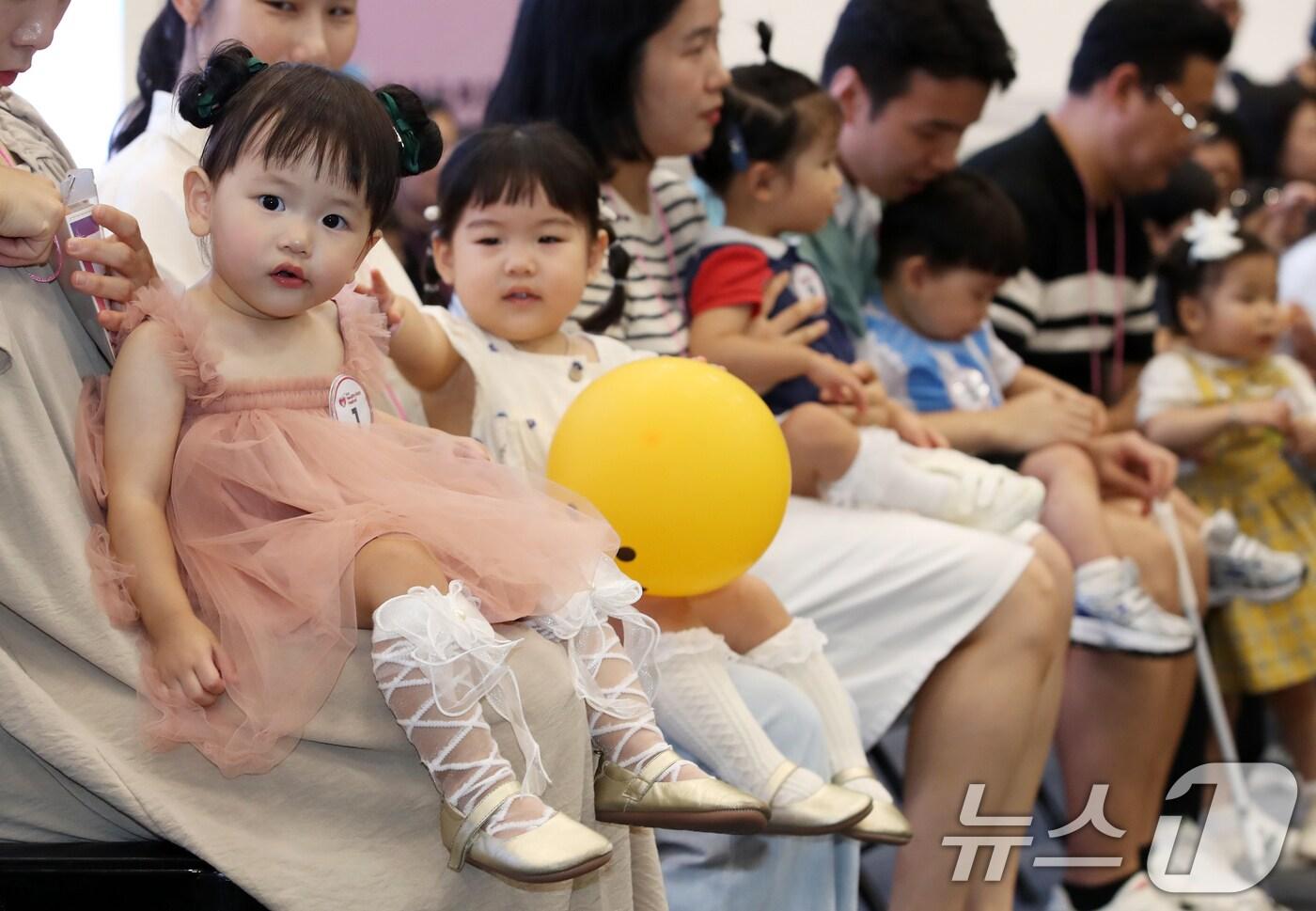 5일 부산 해운대구 벡스코 제1전시장에서 열린 '제1회 헬시·큐티 베이비 페스티벌'에서 큐티 베이비 부문에 참가한 아기들이 부모와 함께 무대에 올라 관객석을 바라보고 있다. 오는 6열까지 열리는 이번 행사는 결혼과 출산에 대한 긍정적인 동기를 부여하기 위해 처음으로 마련됐다. 큐티 베이비 페스티벌은 생후 13~16개월의 귀여운 아기를 뽑는 행사로 잘 웃고 개성 넘치는 아기, 부모와의 유대가 좋은 아기를 선발한다. 2025.9.5/뉴스1 ⓒ News1 윤일지 기자