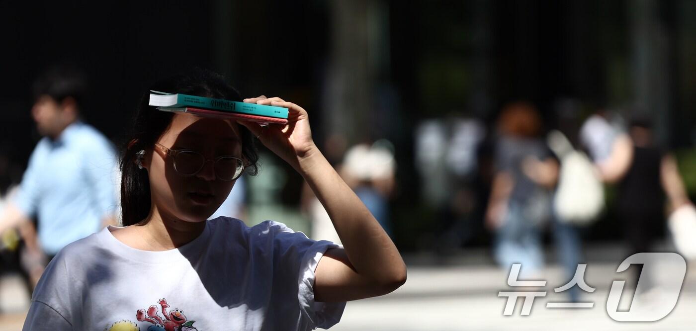 서울 낮 기온이 30도 이상 오르며 푹푹 찌는 무더위가 이어진 5일 오후 서울 종로구 일대에서 시민이 책으로 햇볕을 가리며 발걸음을 옮기고 있다. 2025.9.5/뉴스1 ⓒ News1 김민지 기자