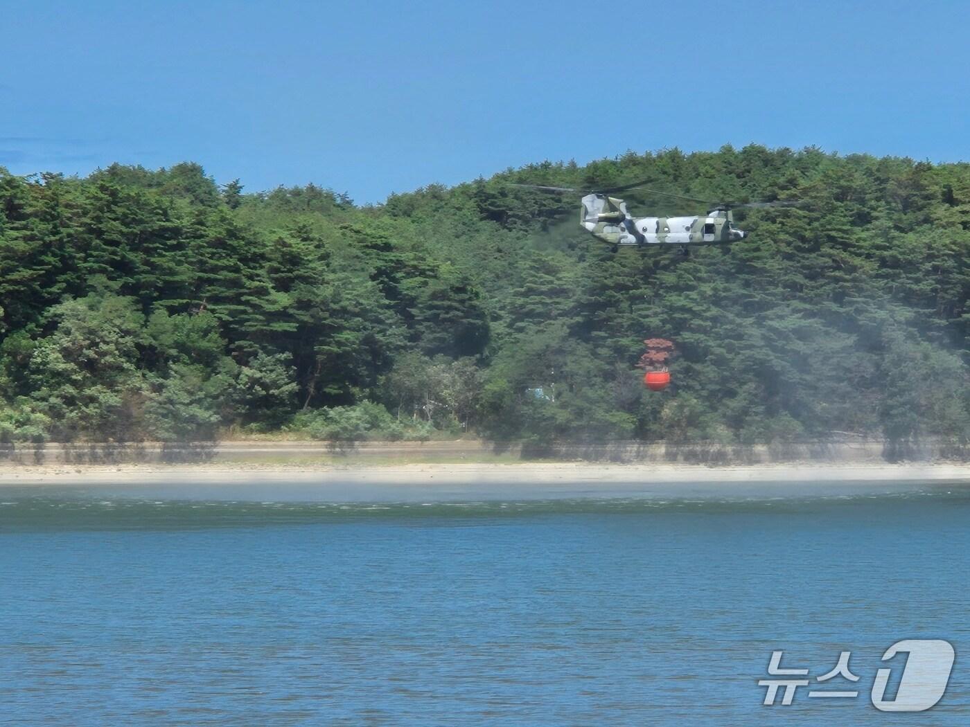 본문 이미지 - 5일 낮 강원 강릉시 장현저수지에서 육군 시누크 헬기로 추정되는 헬리곱터가 담수를 위해 낮게 비행하고 있다. 2025.9.5/뉴스1 윤왕근 기자