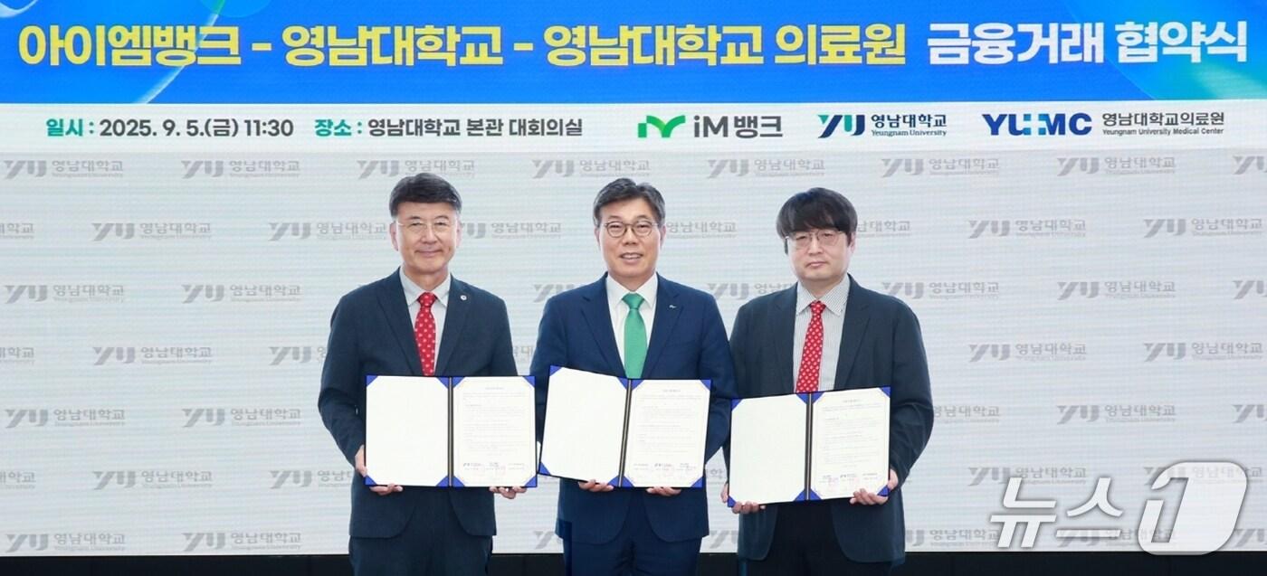 최외출 영남대 총장(왼쪽부터), 황병우 iM뱅크 은행장, 이준 영남대병원 병원장이 금융거래업무 협약을 체결한 뒤 협약서를 펼쳐 보이고 있다.(iM뱅크 제공. 재판매 및 DB 금지)