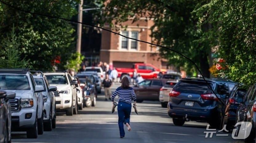 본문 이미지 - 총격 사건 소식을 듣고 뛰어가는 한 여성. (스타 트리뷴 홈페이지 캡처)