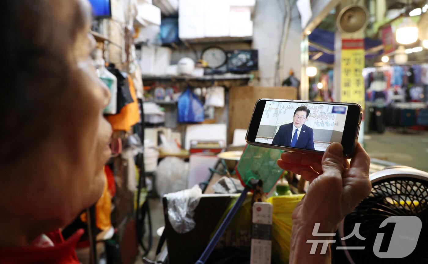 이재명 대통령 취임 100일을 앞두고 전주 남부시장에서 한 상인이 핸드폰으로 이재명 대통령 관련 뉴스를 시청하고 있다. ⓒ News1 유경석 기자