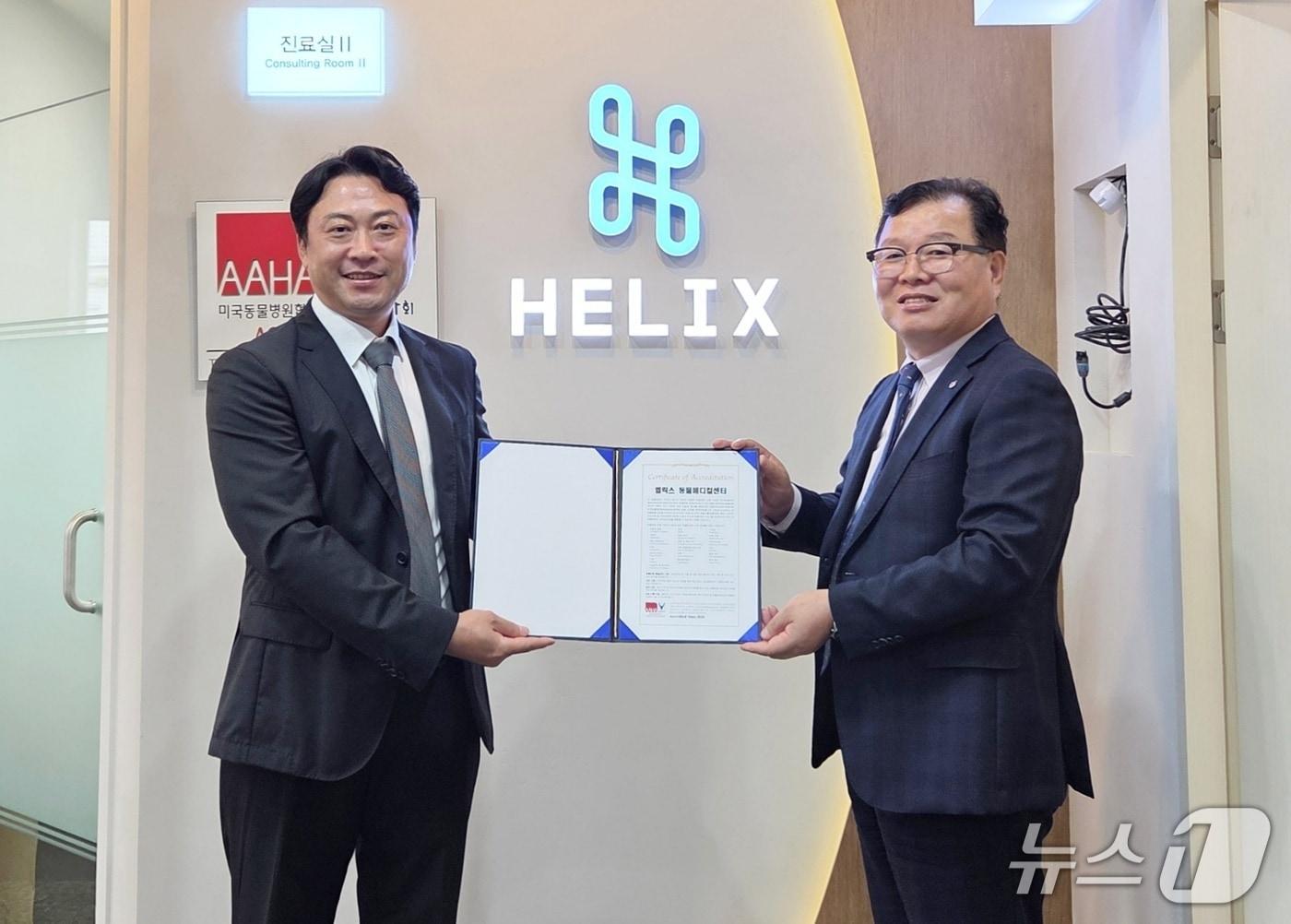 본문 이미지 - 허주형 대한수의사회 회장&#40;오른쪽&#41;이 4일 황정연 헬릭스동물메디컬센터 대표원장에게 AAHA 인증서를 전달하고 있다. ⓒ 뉴스1