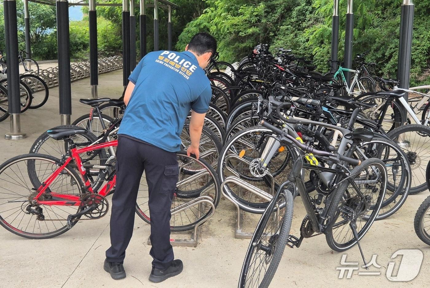 충북 진천경찰서의 한 경찰관이 자전거 절도 예방을 위해 자전거 보관소를 찾아 잠금장치 등을 확인하고 있다.(진천경찰서 제공, 재판매 및 DB금지)/뉴스1