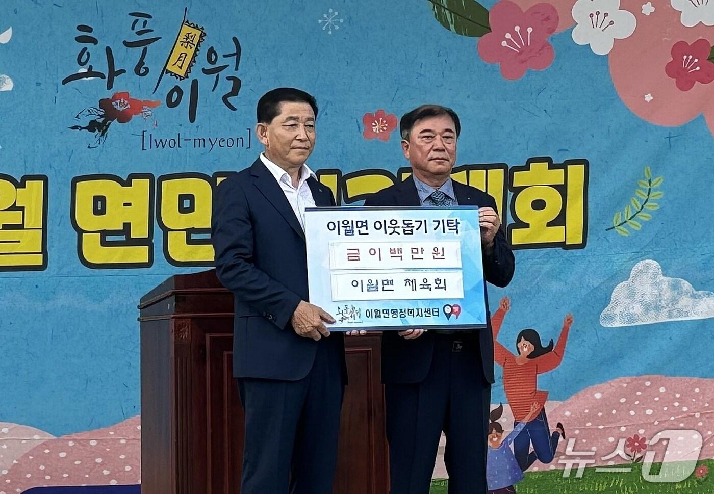 김갑서 충북 진천군 이월면체육회장(왼쪽)이 6일 이종철 이월면장에게 이웃돕기 성금 200만 원을 기탁했다.(진천군 제공)/뉴스1
