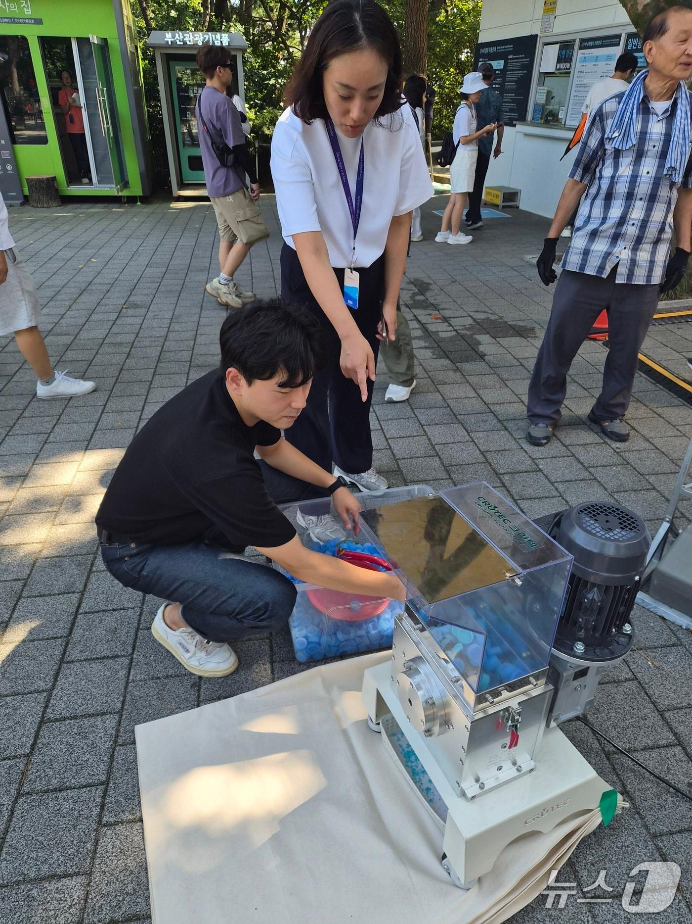 본문 이미지 - 부산관광공사 임직원이 폐플라스틱 병뚜껑을 활용한 업사이클링 기념품을 준비하고 있다.(부산관광공사 제공. 재판매 및 DB금지)