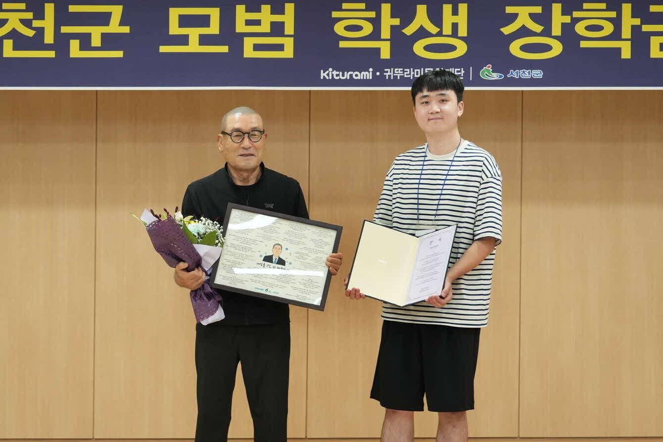 본문 이미지 - 최진민 귀뚜라미그룹 회장(왼쪽)이 학생에게 장학증서를 전달하고 있다.(서천군 제공. 재판매 및 DB금지)/뉴스1