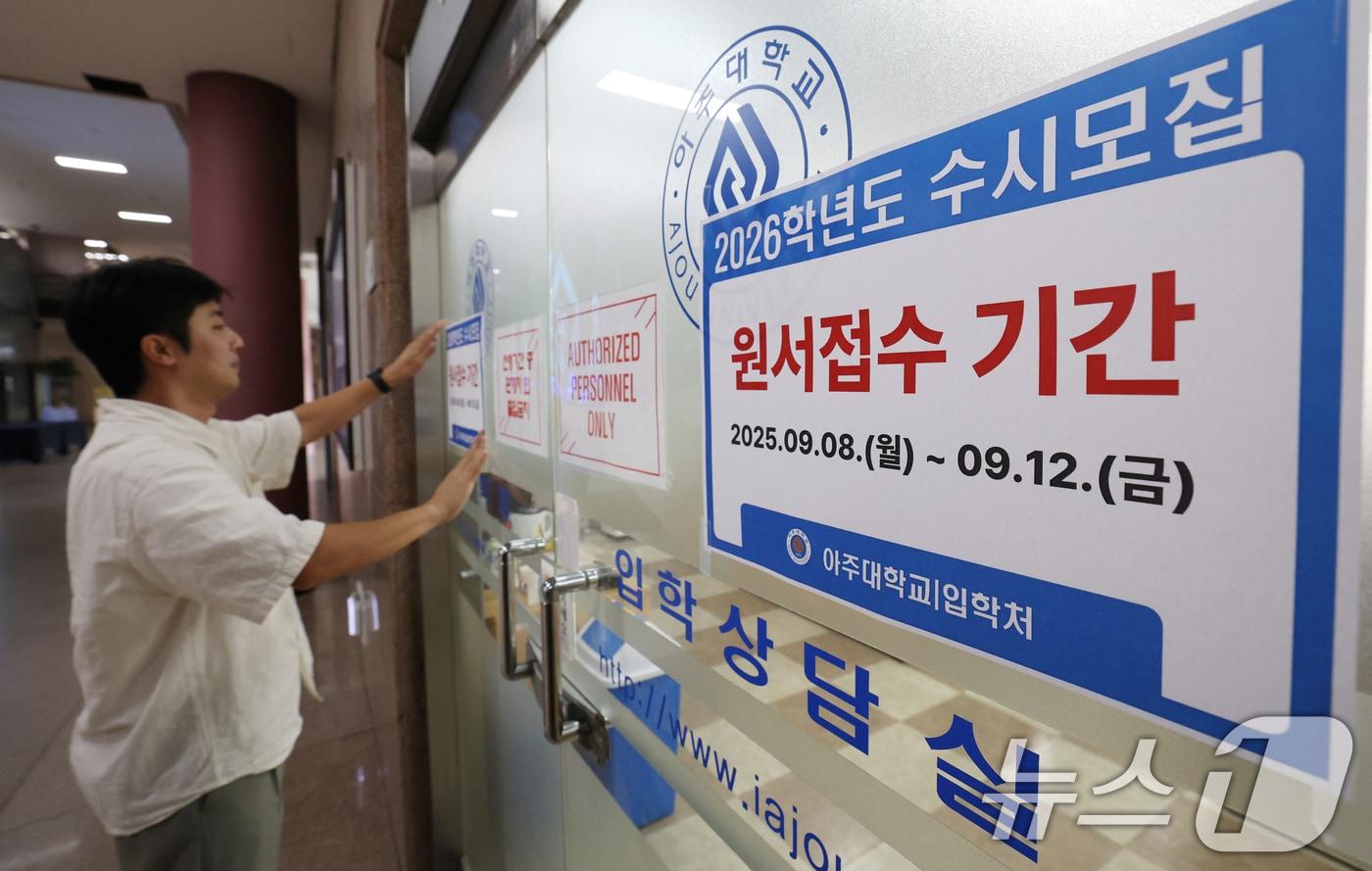 본문 이미지 - 2026학년도 수시모집 원서 접수가 시작된 8일 경기 수원시 영통구 아주대학교 입학처 앞에 관계자가 2026학년도 수시모집을 알리는 게시물을 부착하고 있다. 수험생들은 오는 12일까지 6장의 원서를 희망하는 4년제 대학에 접수할 수 있다. 올해 수시 모집에서는 전체 34만 5179명 중 79.9%(27만 5848명)를 선발한다. 2025.9.8 ⓒ 뉴스1 김영운 기자