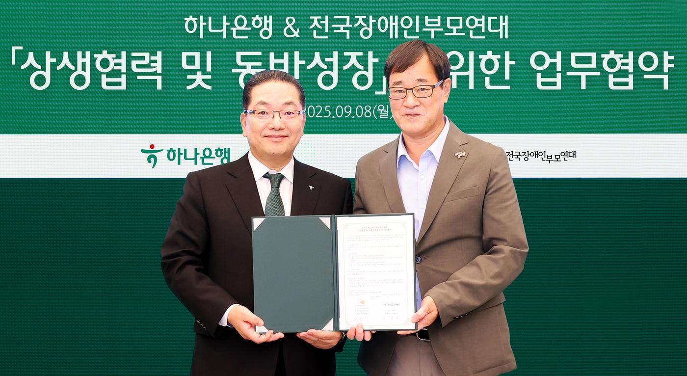 본문 이미지 - 이호성 하나은행장(사진 왼쪽)이 윤종술 전국장애인부모연대 회장(사진 오른쪽)과 협약서를 들고 기념촬영을 하고 있다. (하나은행 제공)