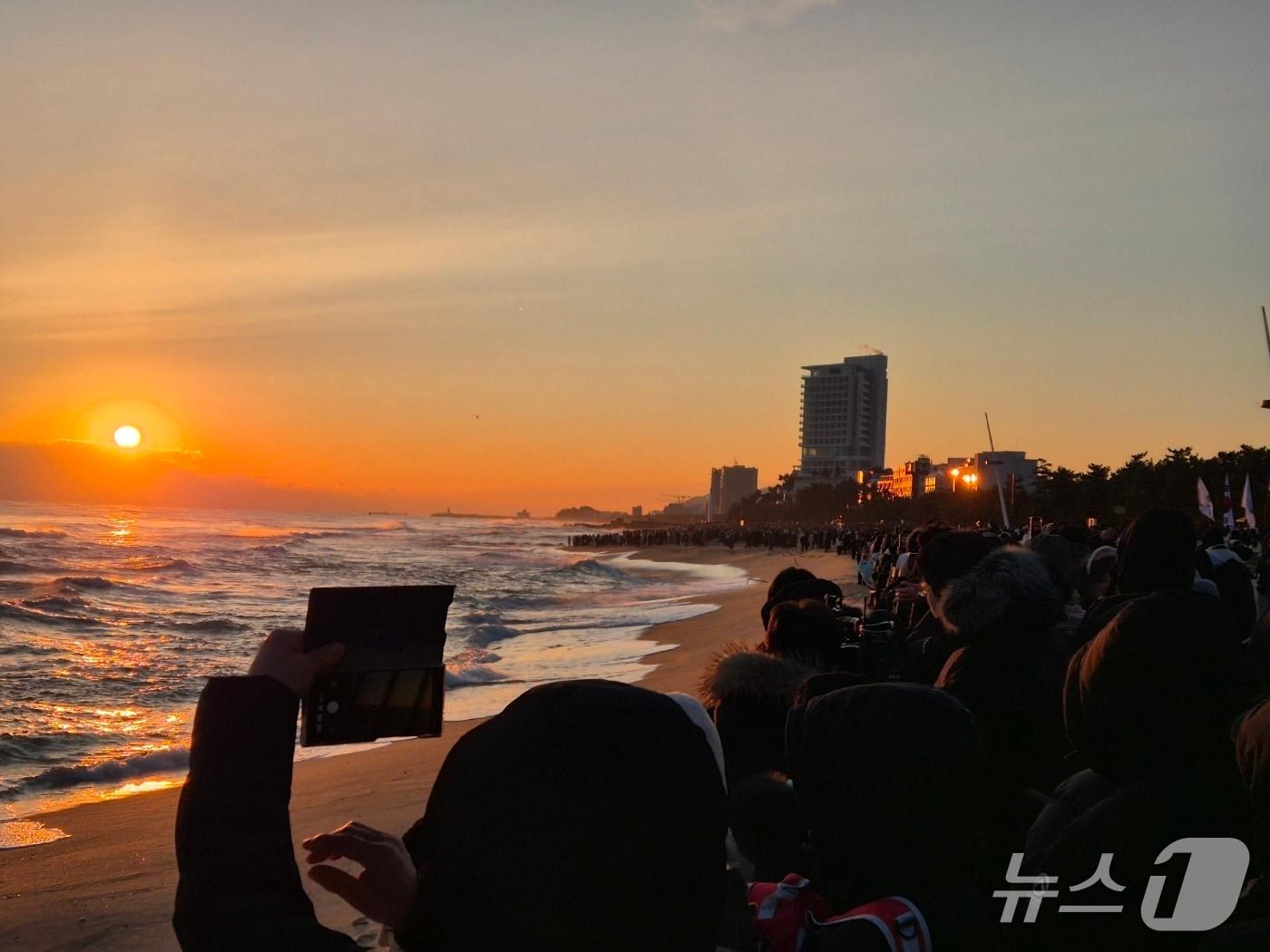 본문 이미지 - 2026년 병오년(丙午年) 새해 첫날인 1일 강원 강릉시 경포해변에서 해가 수평선 위로 떠오르자 시민과 관광객들이 스마트폰으로 장관을 담고 있다. 2026.1.1/뉴스1 윤왕근 기자