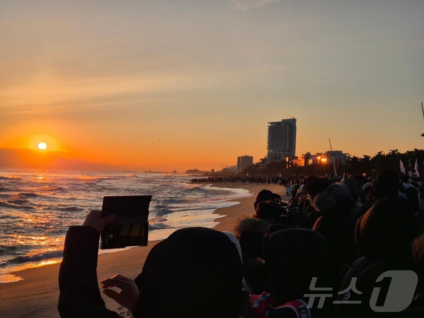 본문 이미지 - 2026년 병오년(丙午年) 새해 첫날인 1일 강원 강릉시 경포해변에서 해가 수평선 위로 떠오르자 시민과 관광객들이 스마트폰으로 장관을 담고 있다. 2026.1.1/뉴스1 ⓒ News1 윤왕근 기자