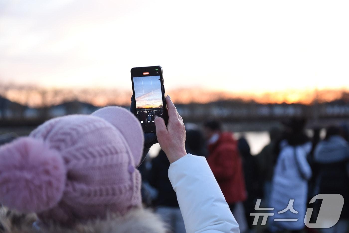 1일 전남 순천시 오천그린광장에 새해 첫 일출을 보러 나온 시민들이 떠오르는 태양을 촬영하고 있다. 2026.1.1/뉴스1 ⓒ News1 김성준 기자