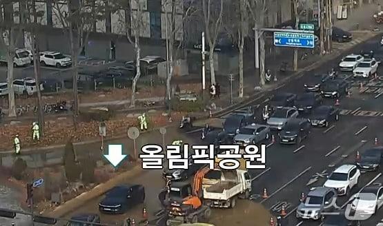 본문 이미지 - 10시 오전 9시쯤 서울 강동구 둔촌사거리 올림픽공원역 방향 도로 아래 매설된 상수도관 파열로 의심되는 누수가 발생해 교통이 통제되고 있다.(경찰청 도시교통정보센터 갈무리)