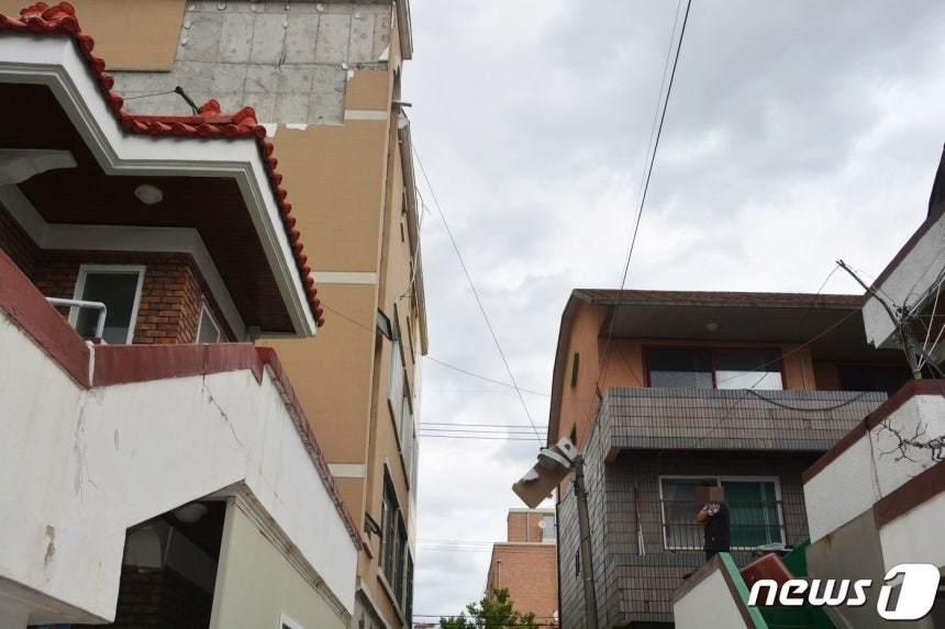 본문 이미지 - 한 건물 외벽이 바람에 파손돼 일부 자재가 전선에 걸려 있다. 2019.9.7/뉴스1
