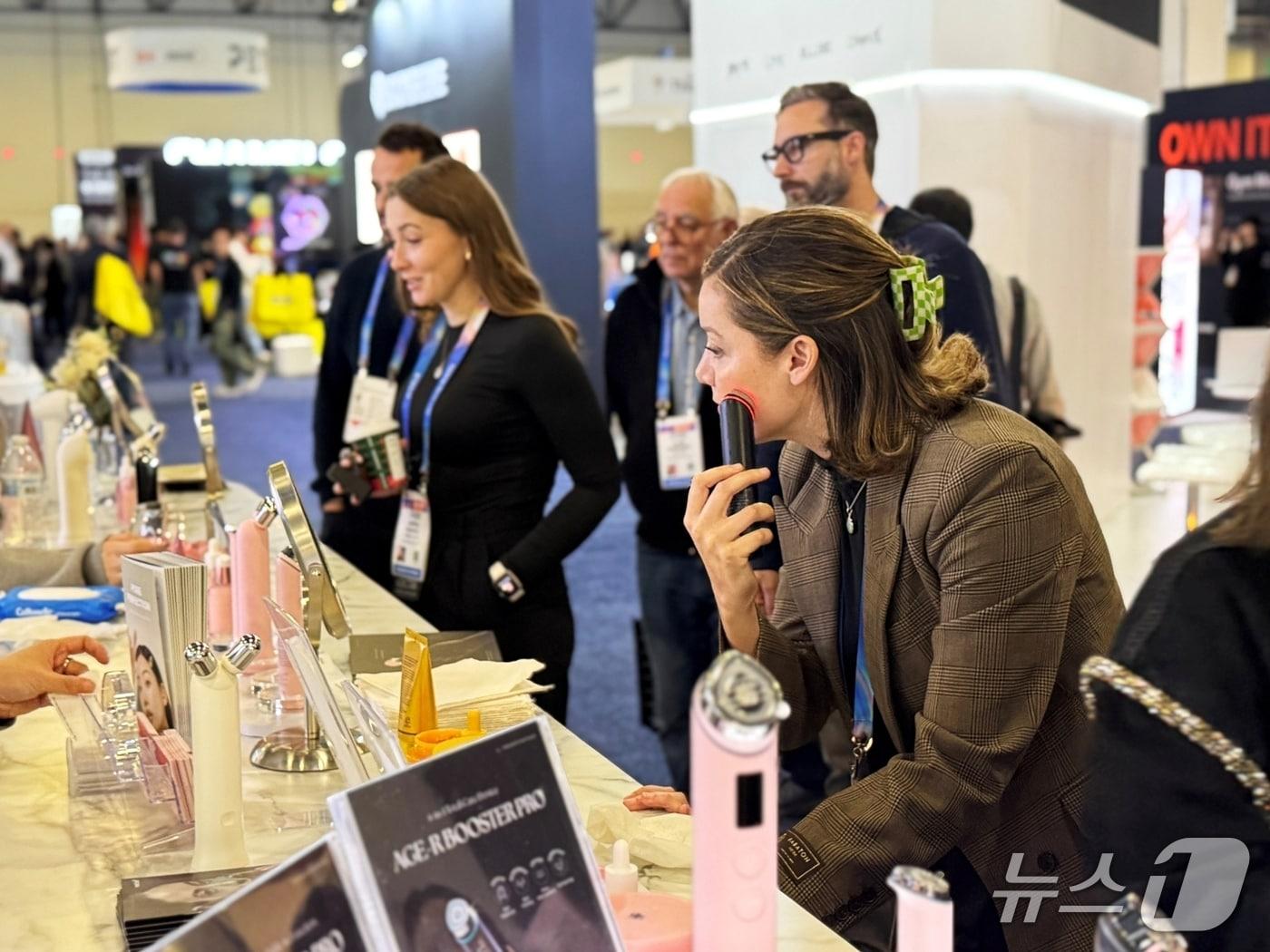 본문 이미지 - 에이피알의 CES 부스를 찾은 방문객이 메디큐브 에이지알 뷰티 디바이스를 체험하고 있는 모습 (에이피알 제공)