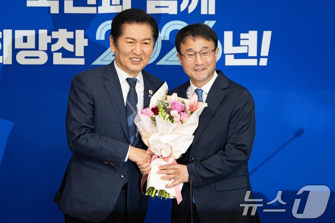 본문 이미지 - 정청래 더불어민주당 대표와 한병도 신임 원내대표가 지난 12일 서울 여의도 국회에서 열린 최고위원회의에 앞서 꽃다발을 들고 기념 촬영을 하고 있다. 2026.1.12/뉴스1 ⓒ News1 유승관 기자