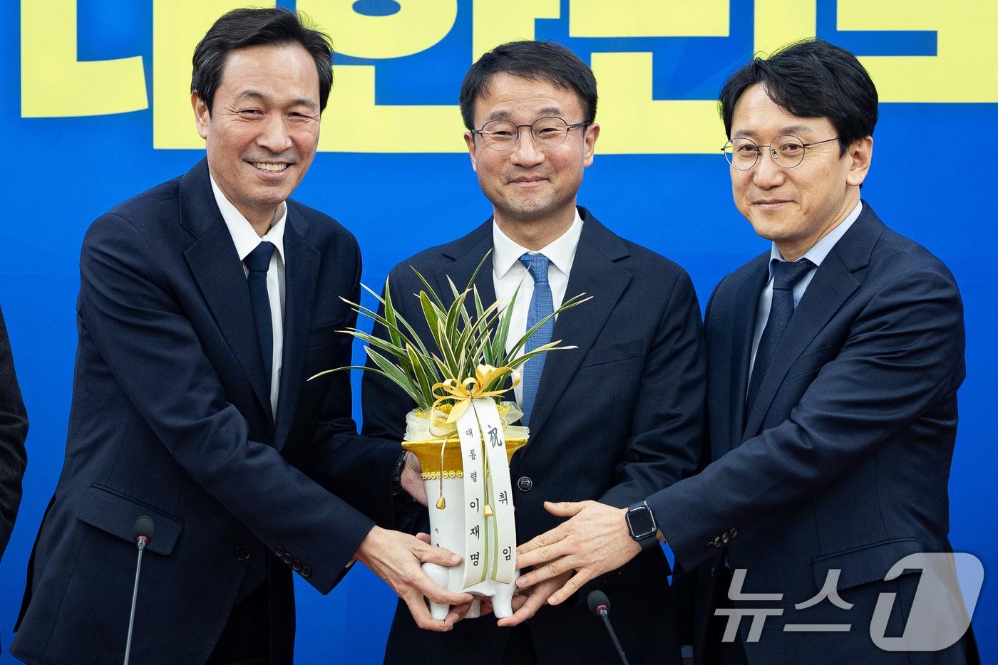 한병도 더불어민주당 신임 원내대표가 12일 서울 여의도 국회에서 우상호 청와대 정무수석을 접견, 이재명 대통령의 취임축하 난을 받아 들고 기념 촬영을 하고 있다. 왼쪽부터 우 수석, 한 원내대표, 천준호 원내운영수석부대표. ⓒ News1 유승관 기자