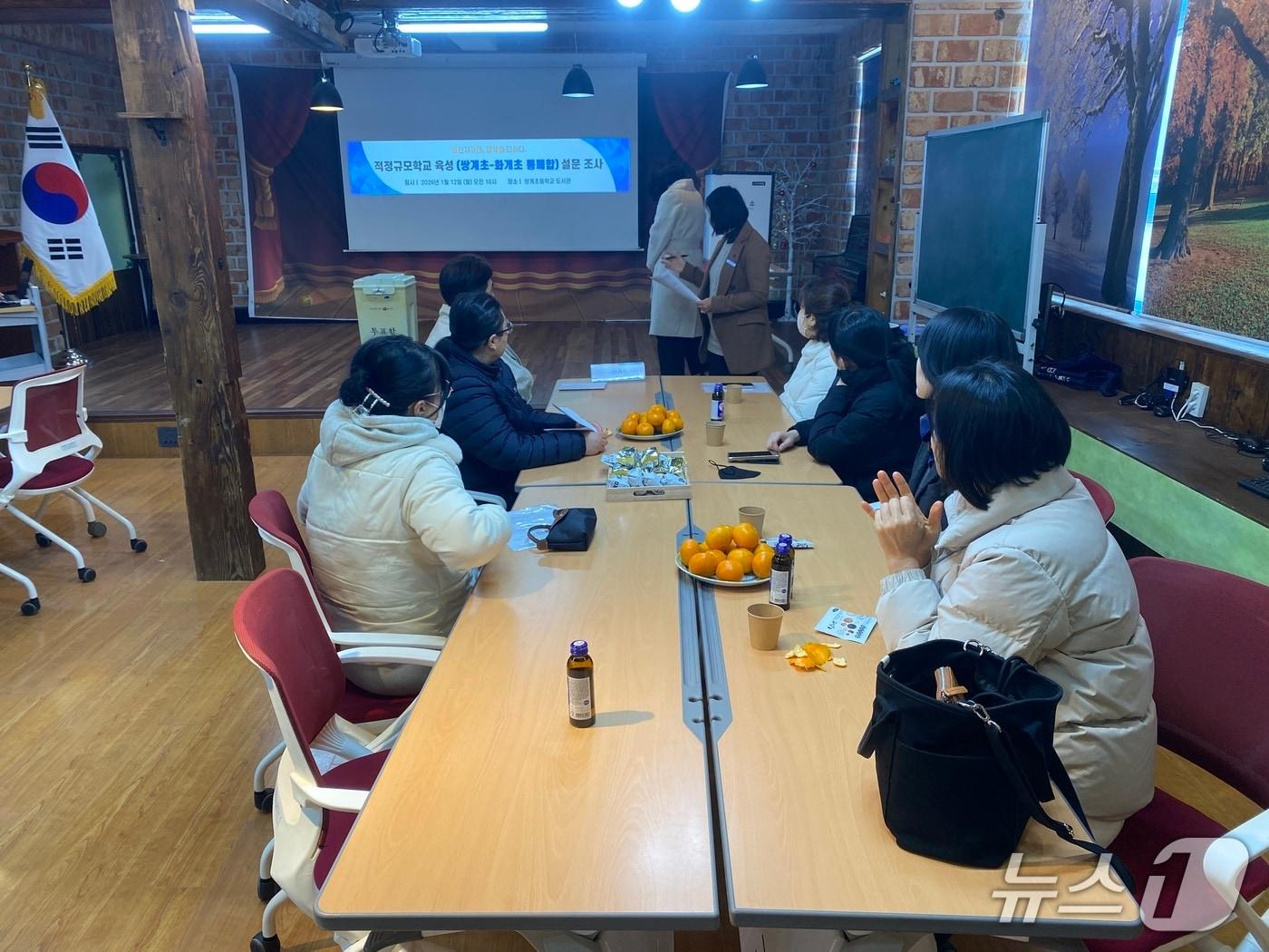 본문 이미지 - 하동 쌍계초등학교 학부모들이 12일 학교 도서관에서 쌍계초-화계초 통폐합 설문조사 투표를 진행하고 있다.(하동교육지원청 제공. 재판매 및 DB금지)